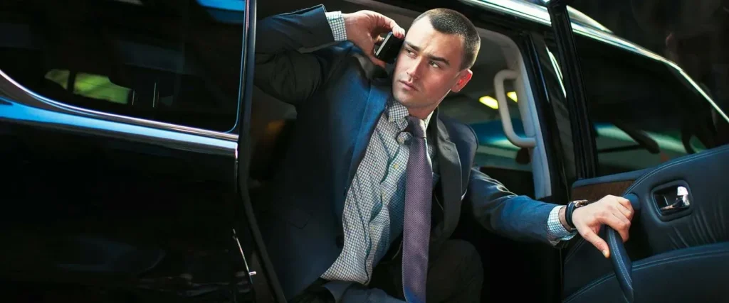 Chauffeur assisting a guest with luggage at a luxury hotel in Houston, showcasing executive car service